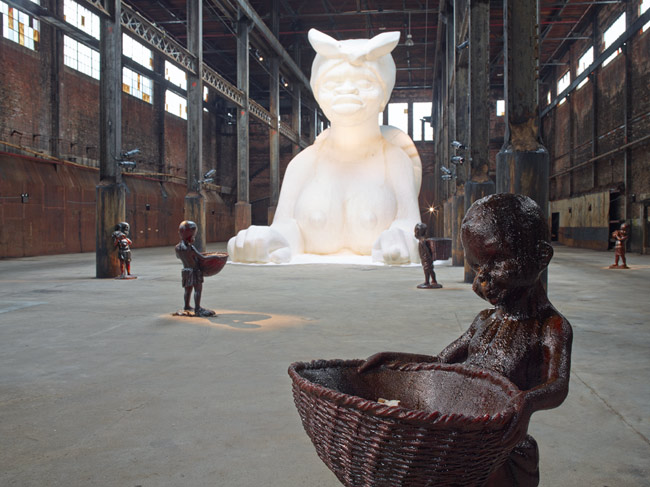 photograph of part of Kara Walker's A Subtlety, depicting female sugar sphinx and molasses children